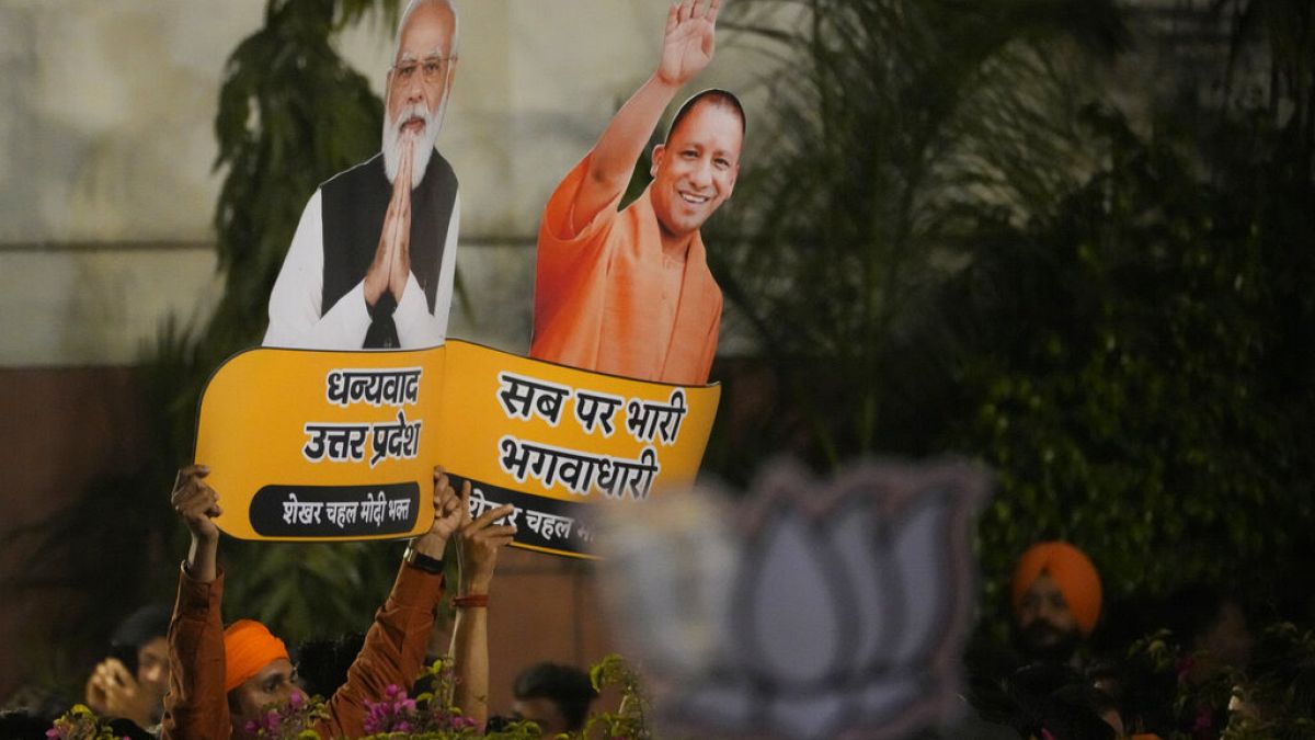 Bharatiya Janata Party supporters hold cuts outs of Indian prime minister Narendra Modi and Uttar Pradesh Chief minister Yogi Adityanath