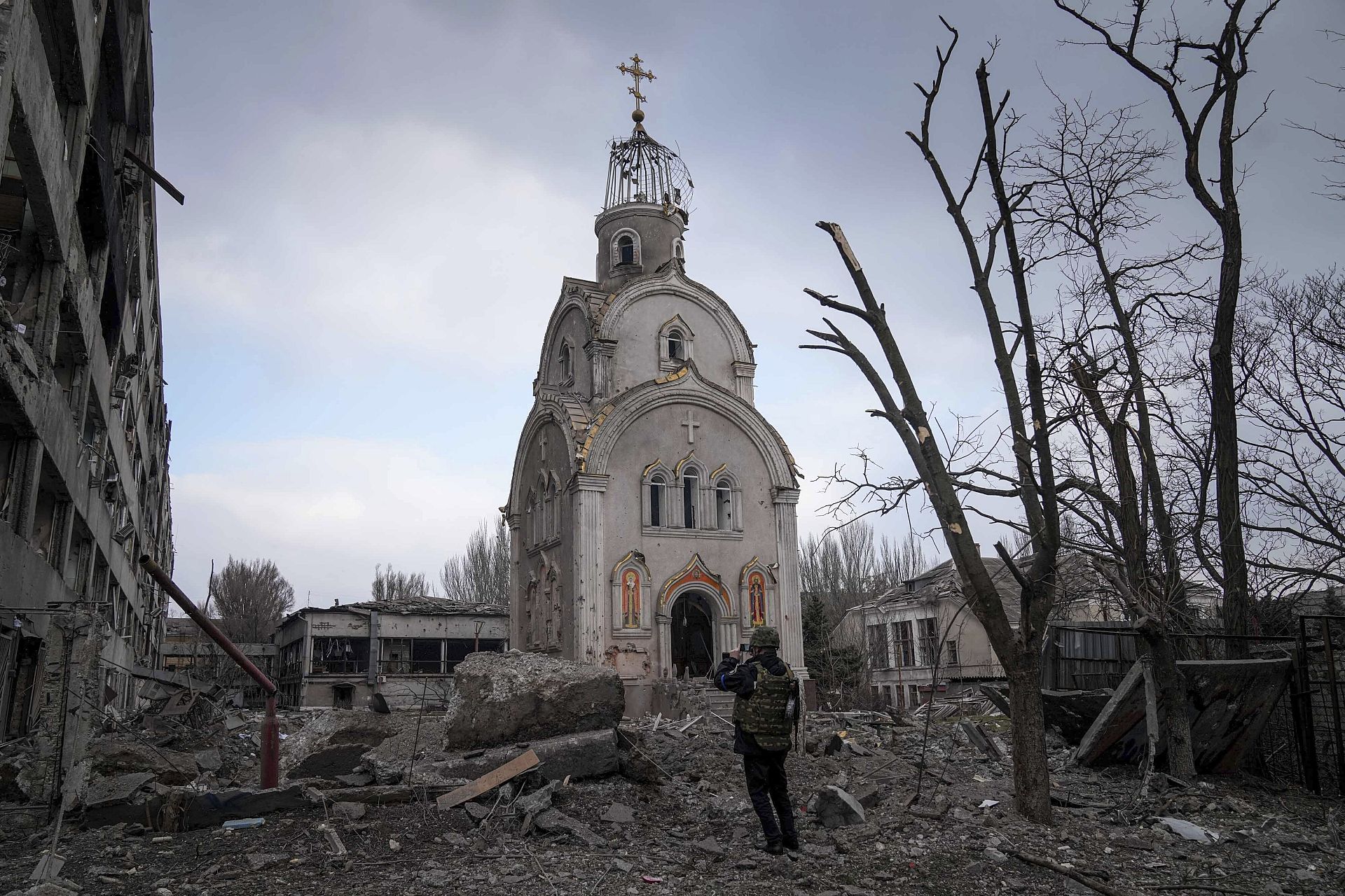 Ukrainian soldier photographs a church damaged by shelling amid the Russian invasion of Ukraine. Mariupol, Ukraine. March 10, 2022