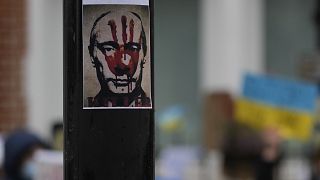 Une affiche de Vladimir Poutine recouverte d'une trace de main ensanglantée, le 1er mars 2022, devant l'ambassade russe à Londres