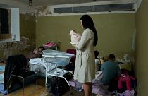 Una mujer sostiene a su hijo recién nacido en el sótano de una maternidad convertida en sala médica y utilizada como refugio antibombas, Kiev, Ucrania