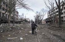 A man walks with a bicycle in a street damaged by shelling in Mariupol, Ukraine, Thursday, 10 March , 2022. 