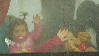Niños refugiados miran desde un autobús que parte hacia Rumanía tras huir de la guerra de la vecina Ucrania