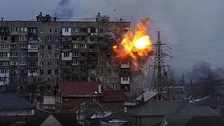 An explosion is seen in an apartment building after Russian's army tank fires in Mariupol