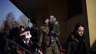 Un soldado polaco sostiene a un niño mientras los refugiados ucranianos llegan de Lviv a la estación de tren de Przemysl, en el sureste de Polonia, el 11 de marzo de 2022.