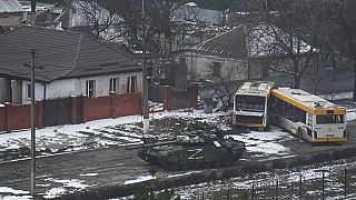 A Russian army tank moves through a street on the outskirts of Mariupol