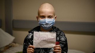 طفل مصاب بالسرطان في كييف يرفع ورقة كتب عليها "أوقفوا الحرب"