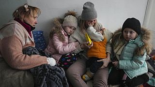 Nők és gyerekek ülnek egy kórház folyosóján Mariupolban, március 11-én