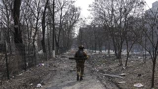 A Ukrainian serviceman walks through Mariupol.