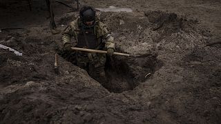A Ukrainian soldier digs a foxhole in Irpin, outskirts of Kyiv, Ukraine, Sunday, 13 March 2022