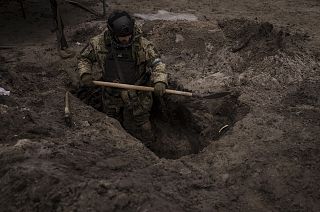 A Ukrainian soldier digs a foxhole in Irpin, outskirts of Kyiv, Ukraine, Sunday, 13 March 2022