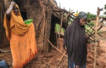 Deux femmes devant une maison détruite par le cyclone au Mozambique