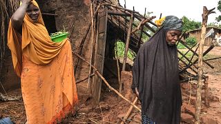 Deux femmes devant une maison détruite par le cyclone au Mozambique