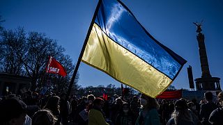 Un manifestant tient un drapeau ukrainien lors d'une manifestation contre l'invasion de l'Ukraine par la Russie, près de la colonne de la Victoire à Berlin, le 13 mars 2022.
