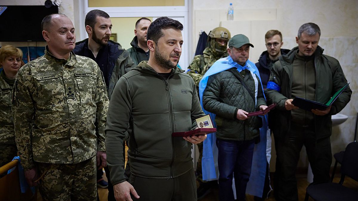 Le président ukrainien Volodomyr Zelensky vient remettre une médaille à un soldat blessé lors de sa visite d'un hôpital de Kyiv le 13 mars 2022