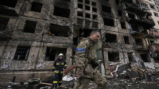 Ukrainian soldiers and firefighters search in a destroyed building after a bombing attack in Kyiv, Ukraine, Monday, March 14, 2022. 