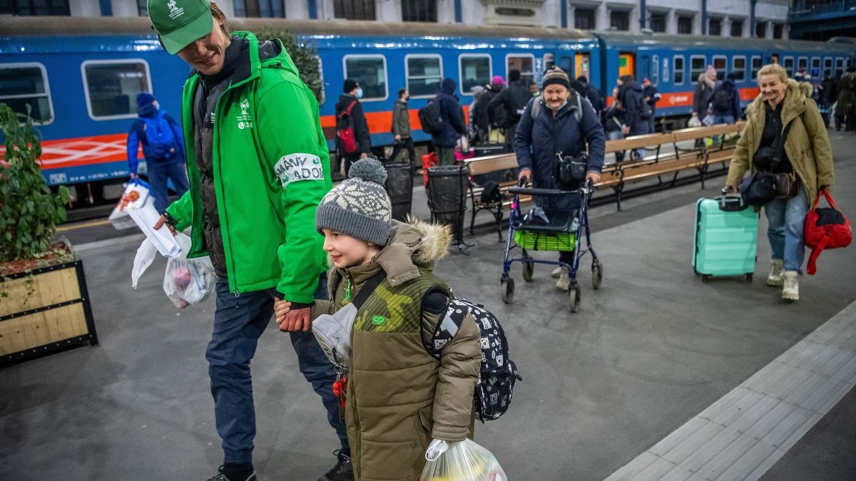 Önkéntes segít a háború miatt Ukrajnából menekülő embereknek Budapesten, a Nyugati pályaudvaron 2022. március 1-jére virradóan