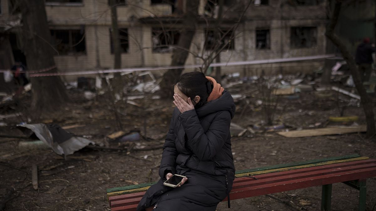 Eine Frau sitzt vor ihrem zerstörten Haus in Kiew, das von russischem Artilleriebeschuss getroffen wurde. (14. März 2022)