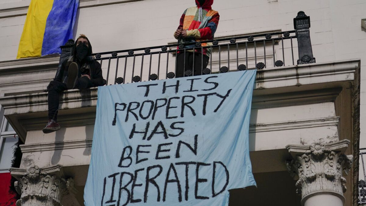 Ukrán zászló és egy plakát egy orosz oligarcha tulajdonában lévő londoni épületen, rajta a szöveg: "Ezt a tulajdont felszabadítottuk" 2022. március 14-én