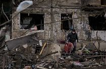 People retrieve belongings from an apartment in a block which was destroyed by an artillery strike in Kyiv, Ukraine, Monday, March 14, 2022. 