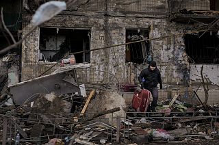 People retrieve belongings from an apartment in a block which was destroyed by an artillery strike in Kyiv, Ukraine, Monday, March 14, 2022. 