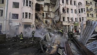 Firefighters extinguish an apartment house after a Russian rocket attack in Kharkiv