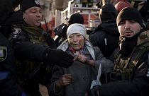 An elderly woman is helped by policemen after she was rescued by firefighters from inside her apartment after bombing in Kyiv, Ukraine, Tuesday, March 15, 2022.
