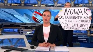 Marina Ovsyannikova tenant sa pancarte derrière la présentatrice vedette du journal télévisé de Pervy Kanal, Ekaterina Andreïeva.
