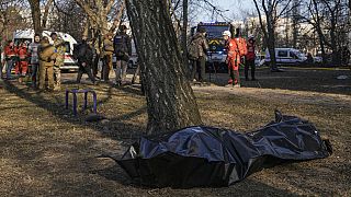 Il corpo di una vittima dei bombardamenti su un condominio di Kiev