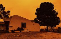 An orange sky is seen over a building in Navares, south eastern Spain on Monday.