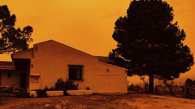 An orange sky is seen over a building in Navares, south eastern Spain on Monday.