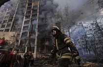 A firefighter walks outside a destroyed apartment building after a bombing in a residential area in Kyiv, Ukraine, Tuesday, March 15, 2022