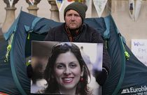 ريتشارد راتكليف، زوج العاملة الخيرية المحتجزة في إيران نازانين زاغاري راتكليف، يحمل صورتها خارج وزارة الخارجية والكومنولث والتنمية في لندن - 9 نوفمبر 2021.