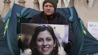 ريتشارد راتكليف، زوج العاملة الخيرية المحتجزة في إيران نازانين زاغاري راتكليف، يحمل صورتها خارج وزارة الخارجية والكومنولث والتنمية في لندن - 9 نوفمبر 2021.