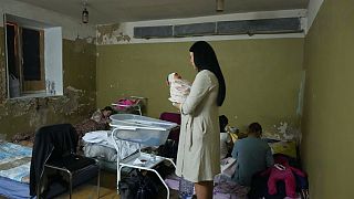 Újszólöttjét tartja kezében egy nő egy kijevi szülészet pincéjében március 2-án, melyet óvóhellyé alakítottak a bombázások miatt