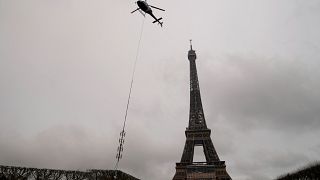 مروحية تركب هوائيًا جديدًا لنقل الاتصالات أعلى برج إيفل في باريس - فرنسا. 2022/03/15