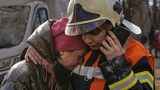Eine Feuerwehrfrau tröstet eine Bewohnerin nach der Bombardierung eines Viertels in Kiew.
