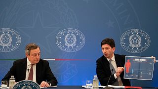 Italian Premier Mario Draghi (L) and Health Minister Roberto Speranza speak to reporters at a press conference.