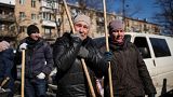 A woman cries before starting to clean the site where a bombing damaged residential buildings in Kyiv, Ukraine, Friday, March 18, 2022. 