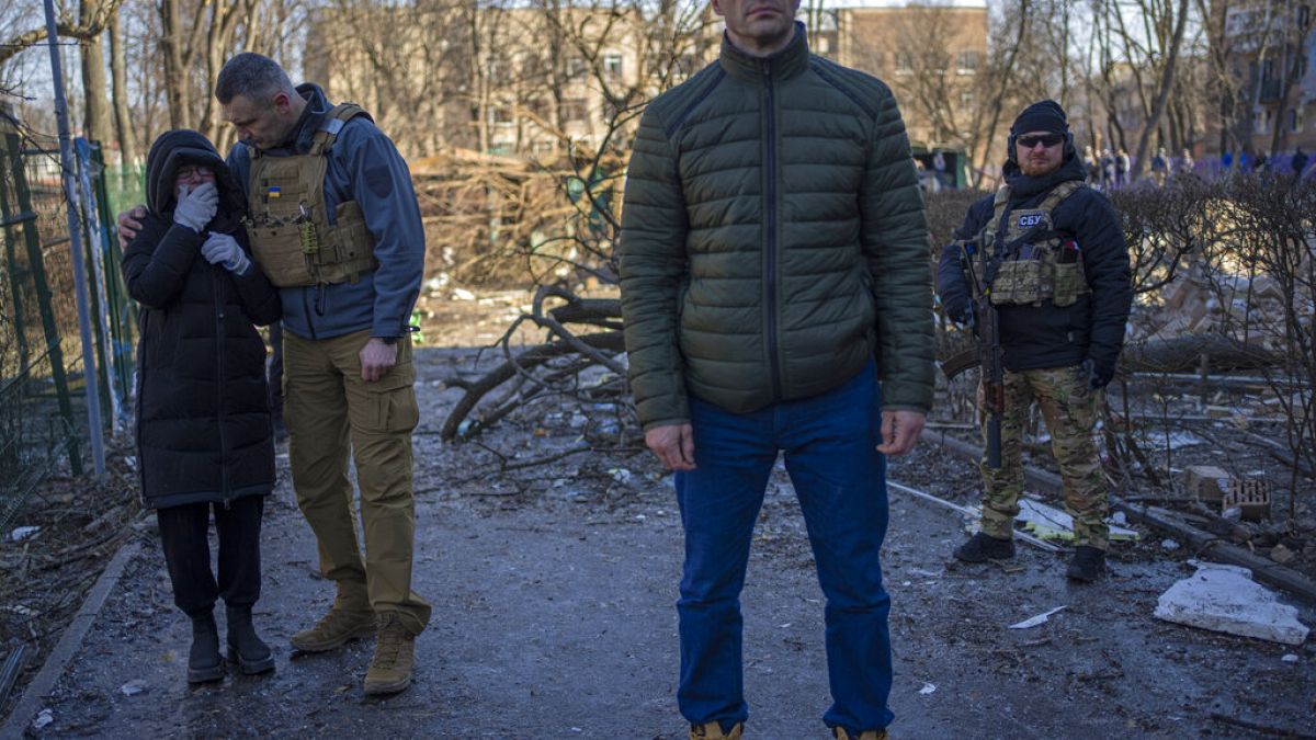 Vlagyimir Klicskó és testvére, Vitalij, Kijev polgármestere egy lebombázott területen Kijevben a helyi lakosokkal