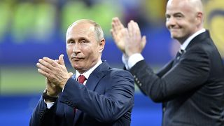 Vladimir Putin, left, applauds besides FIFA President Gianni Infantino