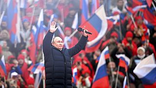 Vladimir Poutine salue la foule après son discours au stade olympique de Moscou, le 18 mars 2022