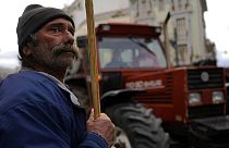 A farmer stands next of tractor during a protest outside of the Agriculture Ministry in Athens
