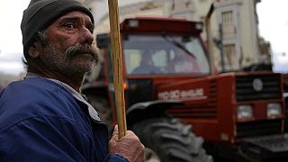 A farmer stands next of tractor during a protest outside of the Agriculture Ministry in Athens