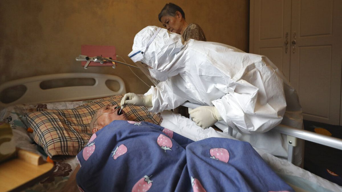 صورة من الارشيف- عامل طبي يأخذ مسحة من أحد السكان لإجراء اختبار فيروس كورونا خلال زيارات منزلية في ووهان، الصين.