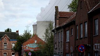 Steam billows from a nuclear power plant behind houses in the village of Doel, Belgium, Monday, Oct. 11, 2021.
