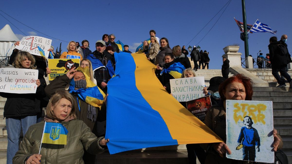 Διαδηλωτές κρατούν τη σημαία της Ουκρανίας, κατά διάρκεια του αντιπολεμικού και αντιρατσιστικού συλλαλητηρίου που πραγματοποιείται στην Αθήνα