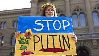 A Protester holds a "Stop Putin" banner