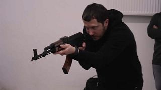 Un instructor voluntario enseña a los civiles a manejar un fusil de asalto