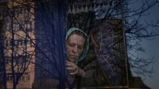 امرأة تنتظر في حافلة للشرطة الأوكرانية لفحص الأوراق والممتلكات في بروفاري - أوكرانيا. 2022/03/20