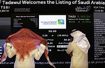 يراقب مسؤولو سوق الأسهم السعودية شاشة سوق الأسهم التي تعرض شركة النفط السعودية أرامكو